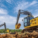 Una Excavadora 200G mueve tierra en un lugar de trabajo con una Excavadora 180P-Tier que también mueve tierra en el fondo.
