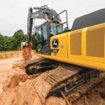 Un primer plano de la Excavadora 250P-Tier mientras descarga tierra en un pozo de trabajo.